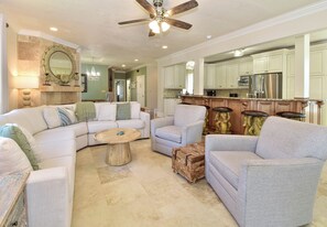 A spacious living room with a large sectional sofa, a coffee table, and a fireplace.