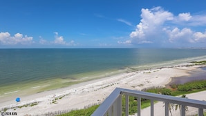 A beach view from a balcony with a railing, clear sky, and calm sea. - Spectacular Deluxe Estero Beach & Tennis Beachfront Condo w/ Direct Gulf View (Fort Myers Beach)