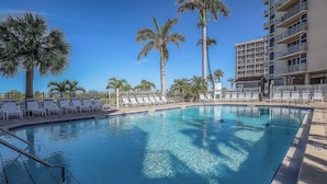 A clear blue pool surrounded by white lounge chairs and palm trees, with a multi-story building in the background. - Spectacular Deluxe Estero Beach & Tennis Beachfront Condo w/ Direct Gulf View (Fort Myers Beach)