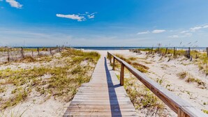 A wooden boardwalk leading to a beach with a clear sky. - Gulf Views | Beach Access | Pet Friendly Coastal Bungalow (Gulf Shores)