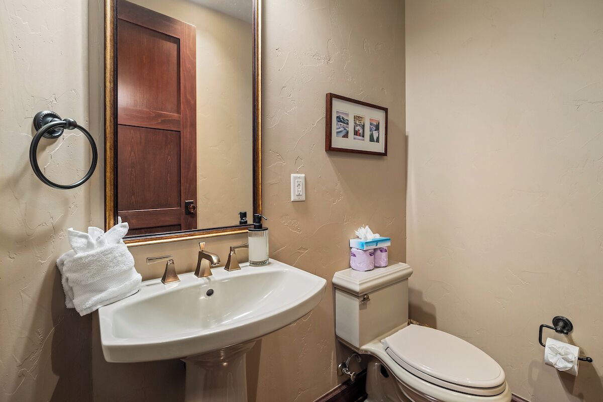 Un baño con lavamanos, inodoro y espejo.