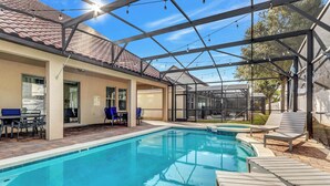 A swimming pool with lounge chairs and a covered patio area. - 5 bed with spa and games room (Davenport)