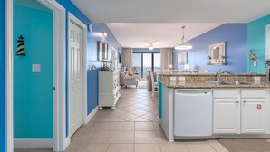 A modern kitchen with a granite countertop, white cabinetry, and a built-in dishwasher. - After Dune Delight ~ 2BR/2BA ~ 15th Floor ~ (Miramar Beach)