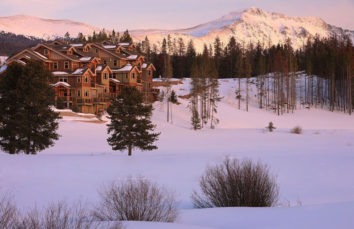 A large lodge with multiple stories and a snow-covered landscape.