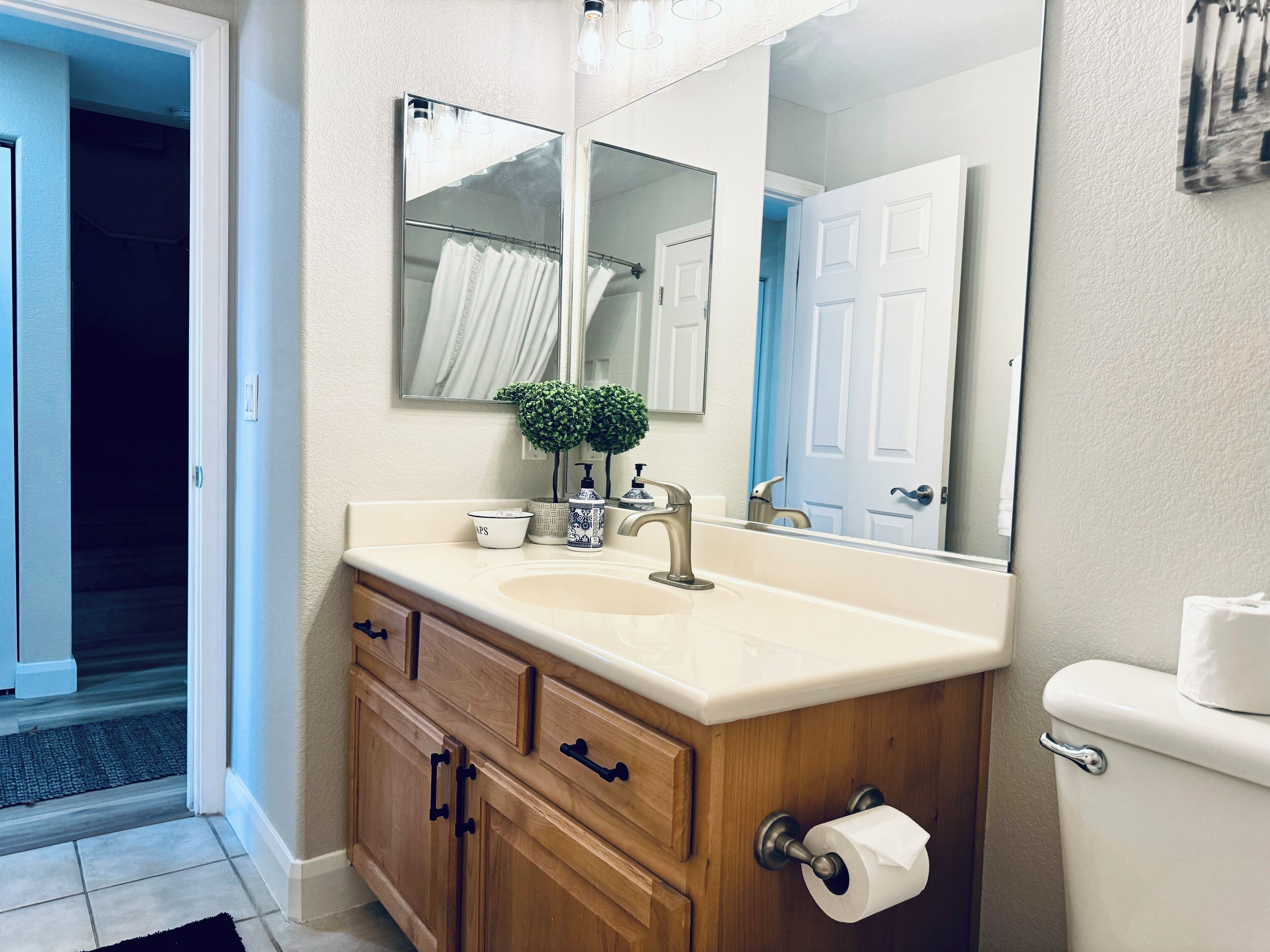 Une salle de bain avec un meuble-lavabo en bois, un évier, un miroir et des toilettes.