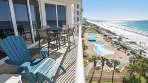 A balcony with a view of a beach and a pool area. - Open-concept, bright beachfront getaway w/private balcony! (Destin)
