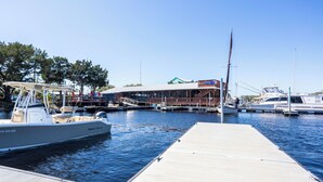 A marina with boats docked, a wooden dock, and a building with a sloped roof in the background. - Remodeled! Waterfront, Rivers Edge Condo #1C-Bldg 1 *DOCK w/ASSIGNED BOAT SLIP! (Steinhatchee)