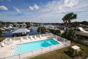 Relax by the tranquil marina pool surrounded by lush greenery and palm trees.