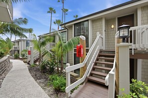 A residential building with a wooden staircase, a fire extinguisher, and a mailbox. - Absolute Beach Front Cottage! Panoramic Views E20 North Coast Village (Oceanside)