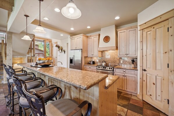 Enjoy a meal in the kitchen with a central island, equipped with a refrigerator, gas stove, and oven.