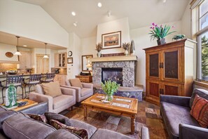 Cozy living area with a fireplace, comfortable seating, and a kitchen area.