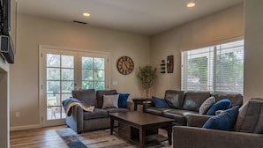 A living room with a sofa, coffee table, and a clock on the wall.