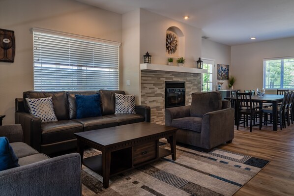 A modern living room with a sofa, armchairs, a coffee table, and a fireplace. - Olive Orchard + Pool + Hot Tub | Hilltop Views | Hidden Hills Olives and Oaks (Templeton)