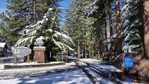 A snow-covered road leading to Lakeland Village Beach & Mountain Resort with a reception and lobby sign.