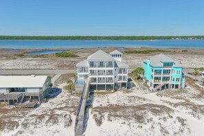 A coastal property with multiple buildings, a dock, and a beach view.