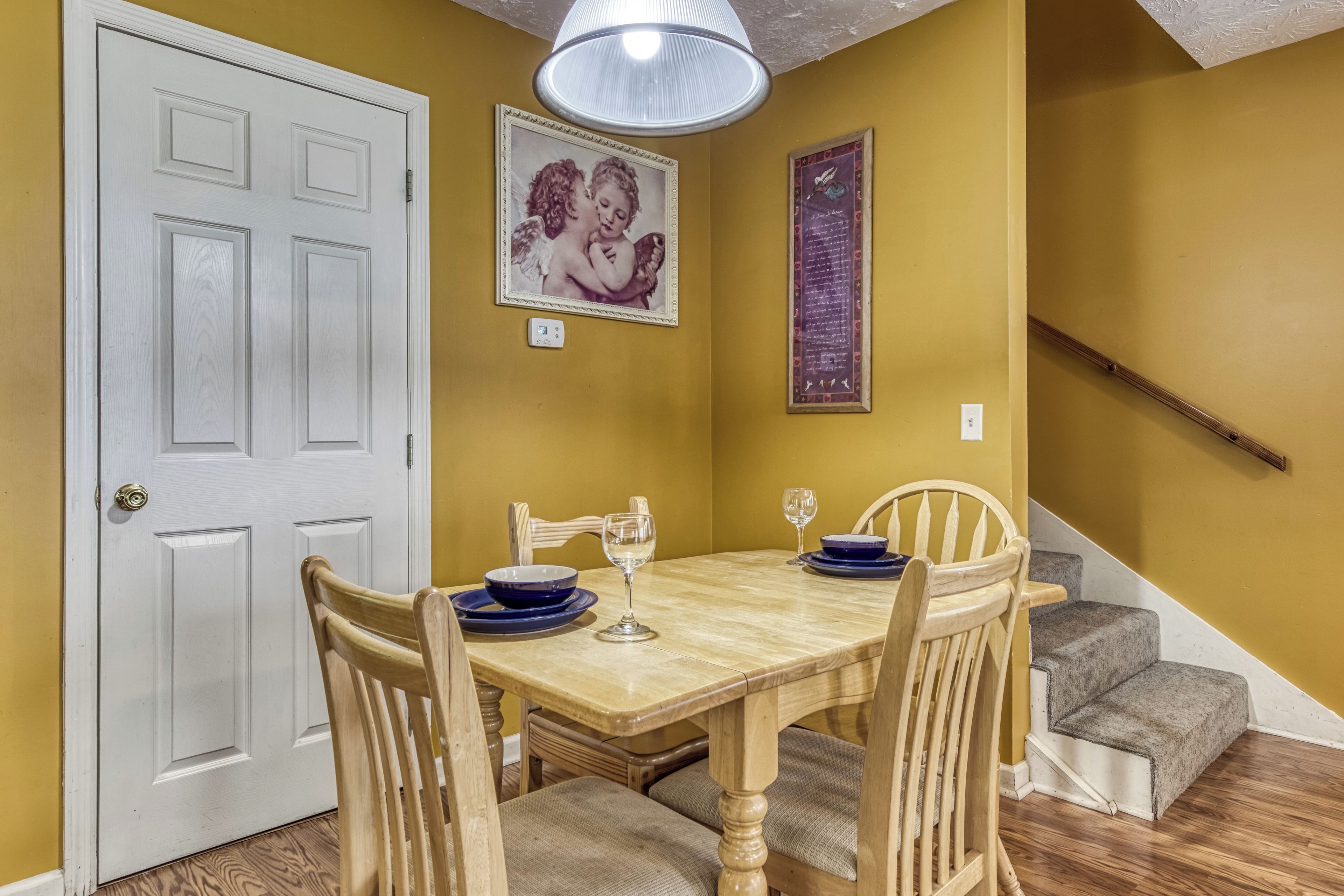 A dining area with a wooden table, chairs, and a chandelier.