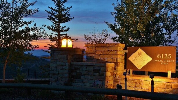 A stone wall with a sign reading "6125 Royal Street West" and a lantern. - Cozy Luxury Studio with Fireplace, Prime Location & Summer Adventure! (Deer Valley)