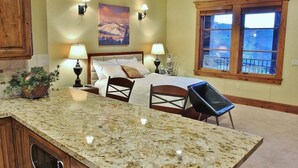 A bedroom with a bed, two bedside lamps, a window, and a view of the outdoors. - Cozy Luxury Studio with Fireplace, Prime Location & Summer Adventure! (Deer Valley)