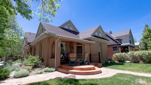 A two-story house with a front porch, a covered patio, and a well-maintained lawn. - Le Petit Soliel - In-Town Home, Ready for Your Whole Family! (Salida)