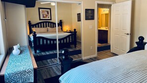 A bedroom with a bed, bedside table, lamp, and a mirror. - Eastview Oasis by Mesquite Vacation Rentals near Wolf Creek Golf Course with $510 in free daily activities (Mesquite)