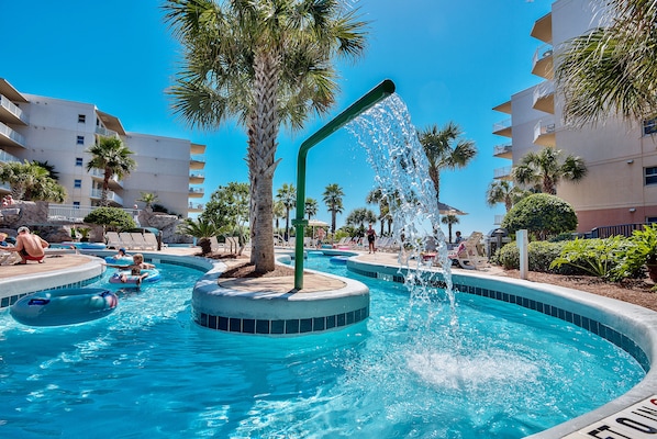A swimming pool with a water feature, palm trees, and a building with balconies. - 4TH Floor, 2 Bed plus Bunkroom Waterscape Condo! BEACH SERVICE INCLUDED! (Fort Walton Beach)