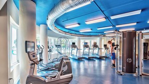 Uma academia com esteiras, elípticos e equipamentos de musculação.