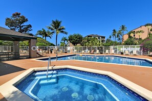 Area piscina con lettini e una zona salotto coperta.