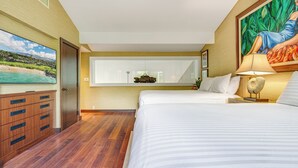 Una camera da letto con un letto, una ventola a soffitto, un comodino con una lampada, un quadro e un comò.