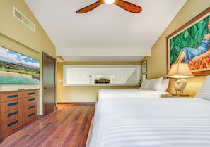 A bedroom with a bed, a ceiling fan, a nightstand with a lamp, a painting, and a dresser.