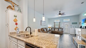 A modern kitchen with granite countertops, a dishwasher, and a dining area with a bench.