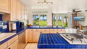 Una cocina moderna con azulejos azules, armarios de madera y vistas al exterior.