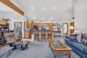 A spacious living room with a leather chair, a blue sofa, and a wooden coffee table. - Beautiful Mountain Townhome with Hot Tub, Convenient Location! HL305 (Breckenridge)