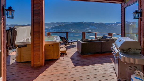 A wooden deck with a hot tub, a grill, and lounge chairs overlooking a mountainous landscape. - Big Sky - Lakeview - TLUXP (Truckee)