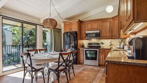 A kitchen with wooden cabinets, a stainless steel refrigerator, an oven, and a microwave.