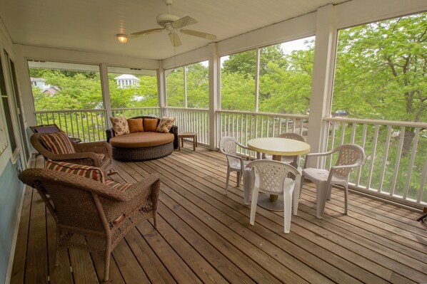 A covered porch with wicker furniture, a round table, and chairs. - 5 Beds in Beachwalk Resort - Beach, Pool, Stocked Lake & Lake Michigan Access (Michigan City)