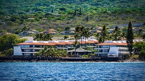 A coastal hotel with multiple buildings, a rocky shoreline, and a view of the ocean.