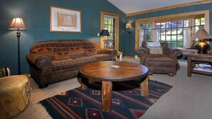 A living room with a sofa, armchair, round coffee table, and a drum. - Gothic Charmer,Charming home on the West End of CB (Crested Butte)