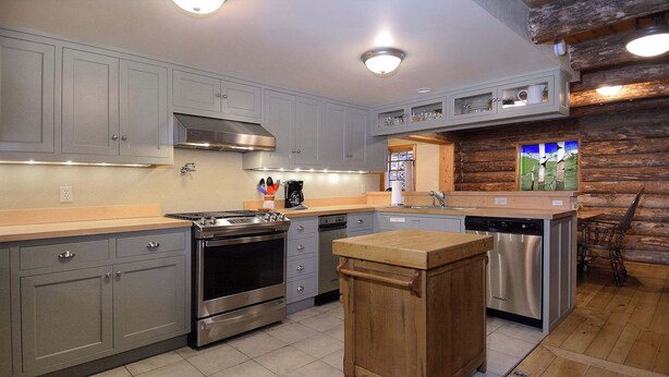 A kitchen with grey cabinets, stainless steel appliances, a wooden island, and a wooden wall. - Gothic Charmer,Charming home on the West End of CB (Crested Butte)