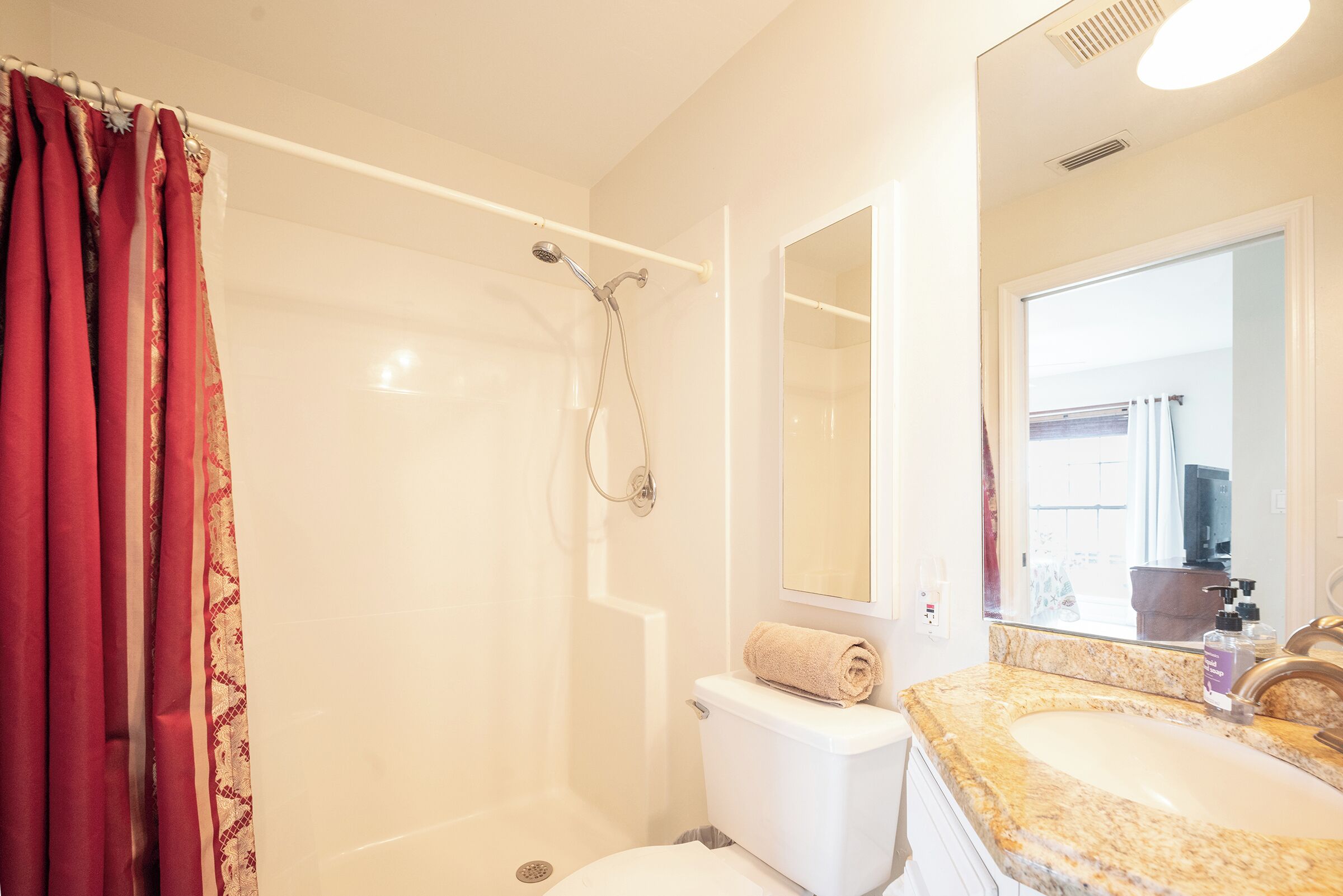 A bathroom with a shower, toilet, and sink.