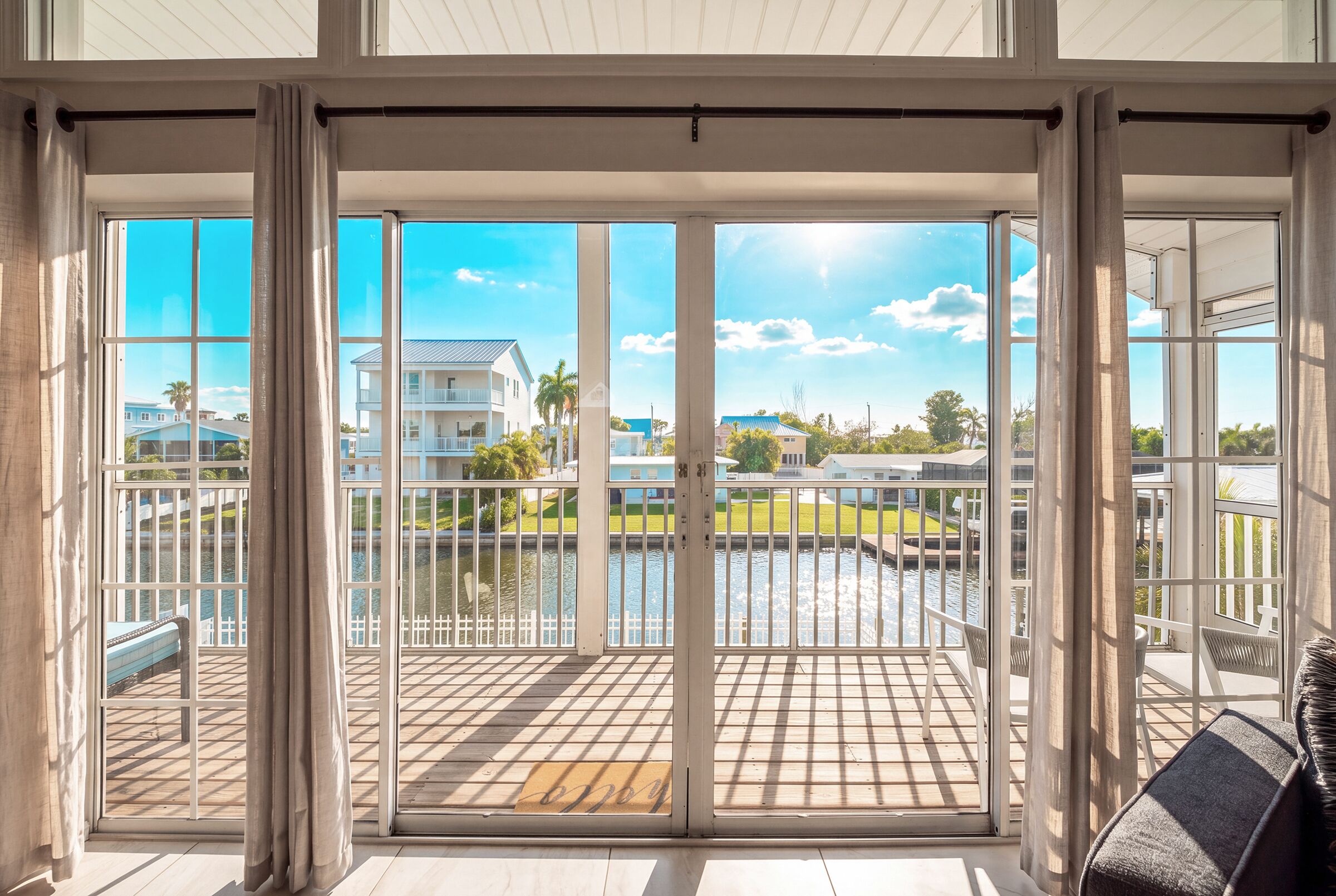 A spacious balcony with a view of a residential area and a body of water.