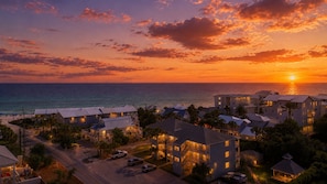 Un hotel frente al mar con varias construcciones y vistas a la puesta de sol.