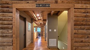 A wooden log cabin interior with a sign reading "YOU HAVE MY HEART" above a doorway.