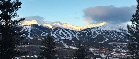 A mountain range with snow-covered peaks and a town at the base.