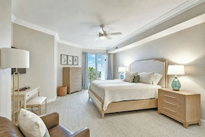A bedroom with a bed, bedside tables, a desk, a chair, a ceiling fan, and a view through a glass door. - 3204 SeaCrest - Direct Oceanfront -March/April Heated Pool (Hilton Head Island)