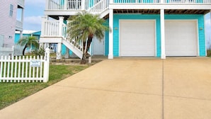 A two-story house with a balcony, a garage, and a white picket fence.