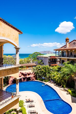 A resort with a swimming pool, outdoor seating, and a view of the ocean. - Sunrise 16☺Family Setting, Big Pool Beach facing in towns ♥ (Tamarindo)