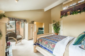 Un dormitorio con cama, una silla, armario y balcón.