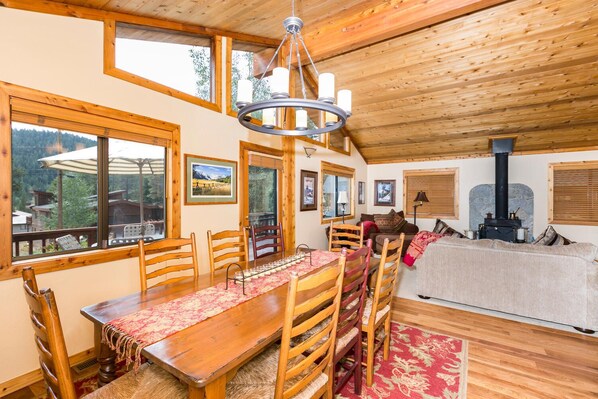 Interior acogedor de una cabaña con comedor, muebles de madera y chimenea.