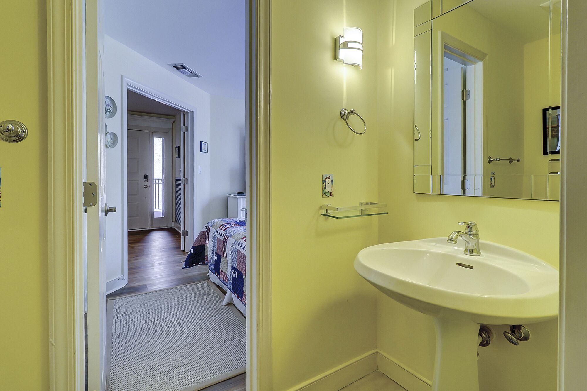 A bathroom with a sink, mirror, and light fixture.