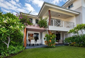 A two-story house with a covered patio, a balcony, and a well-maintained garden. - Discover luxury at Leilani Kai, a 3BR condo in beautiful Waikoloa, HI. (Waikoloa Village)